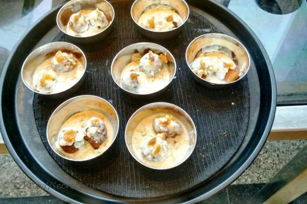 photo of gulgule / pua in rabdi ( sweet dumplings in densed condensed milk)